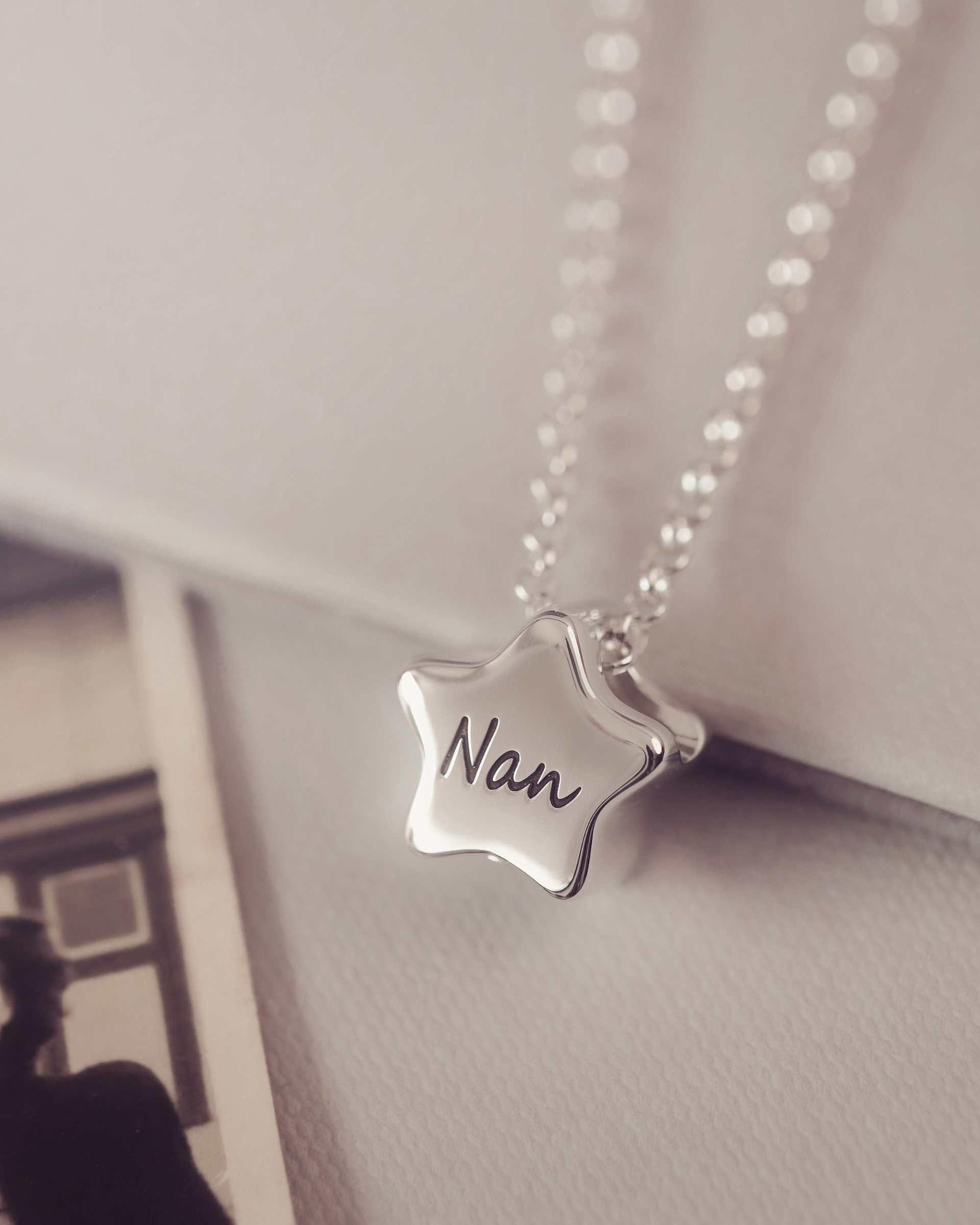 Star-shaped pendant necklace with 'Nan' engraved, hanging against a neutral background.