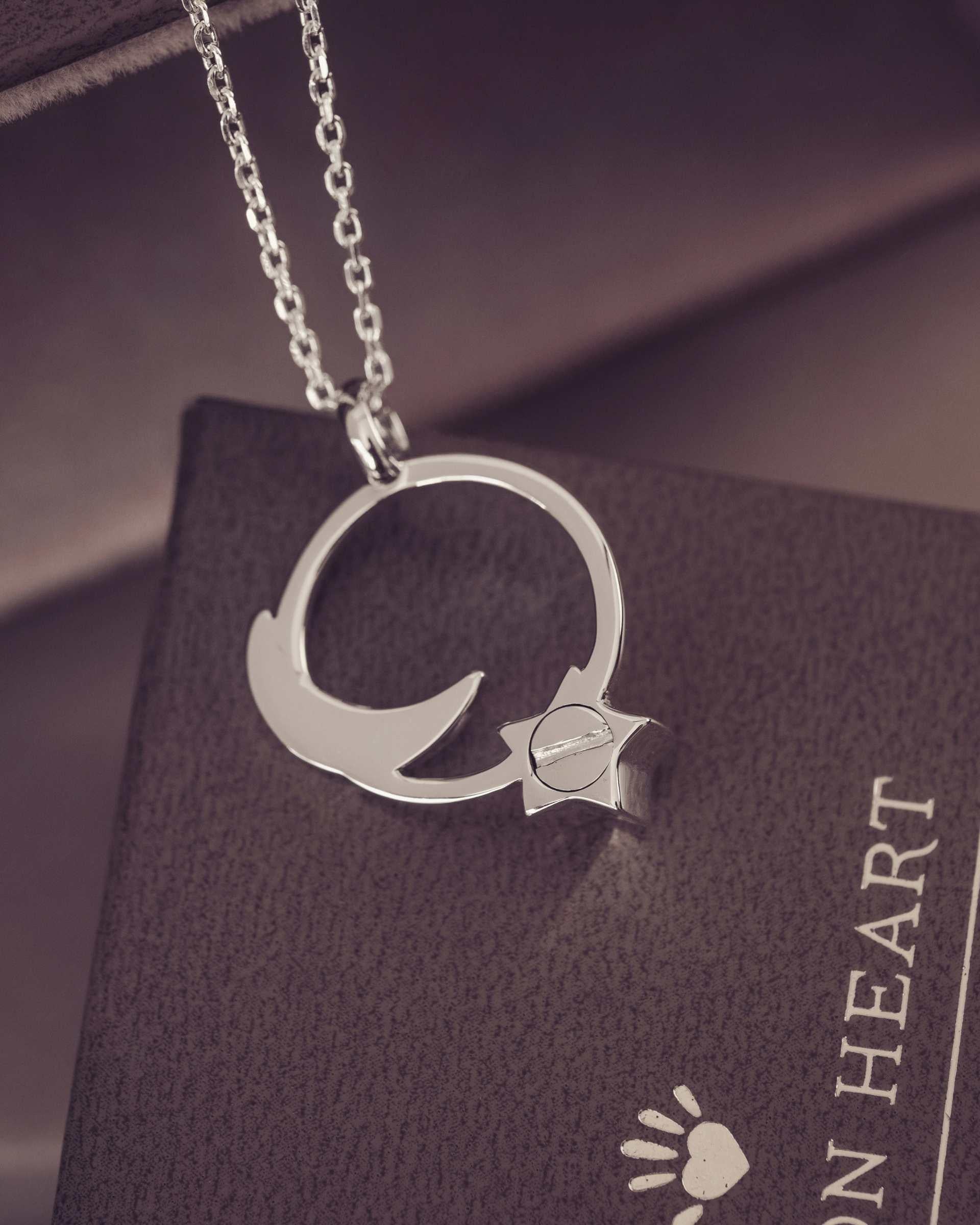 Silver necklace with a pendant on a dark surface