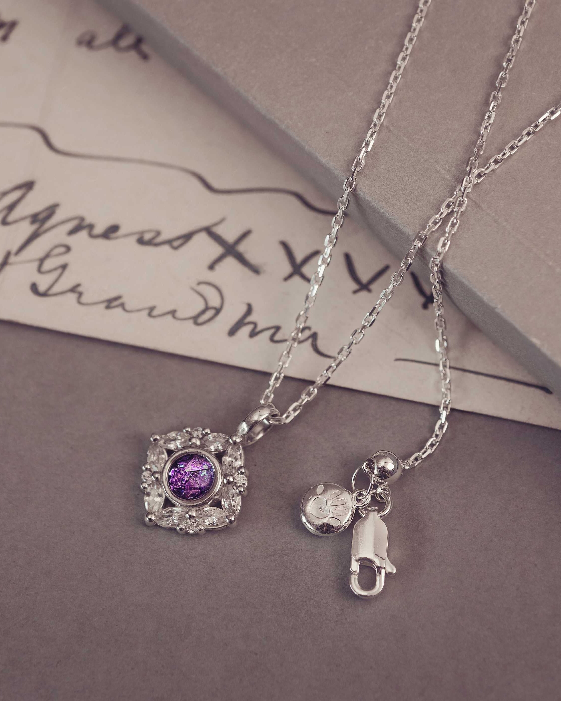 Silver necklaces with charm on a textured surface