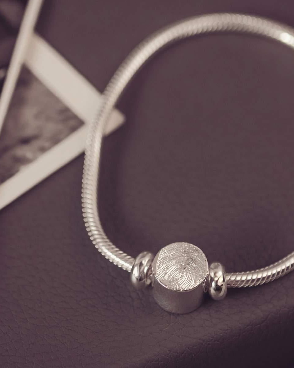 Silver bracelet with a round bead on a dark surface