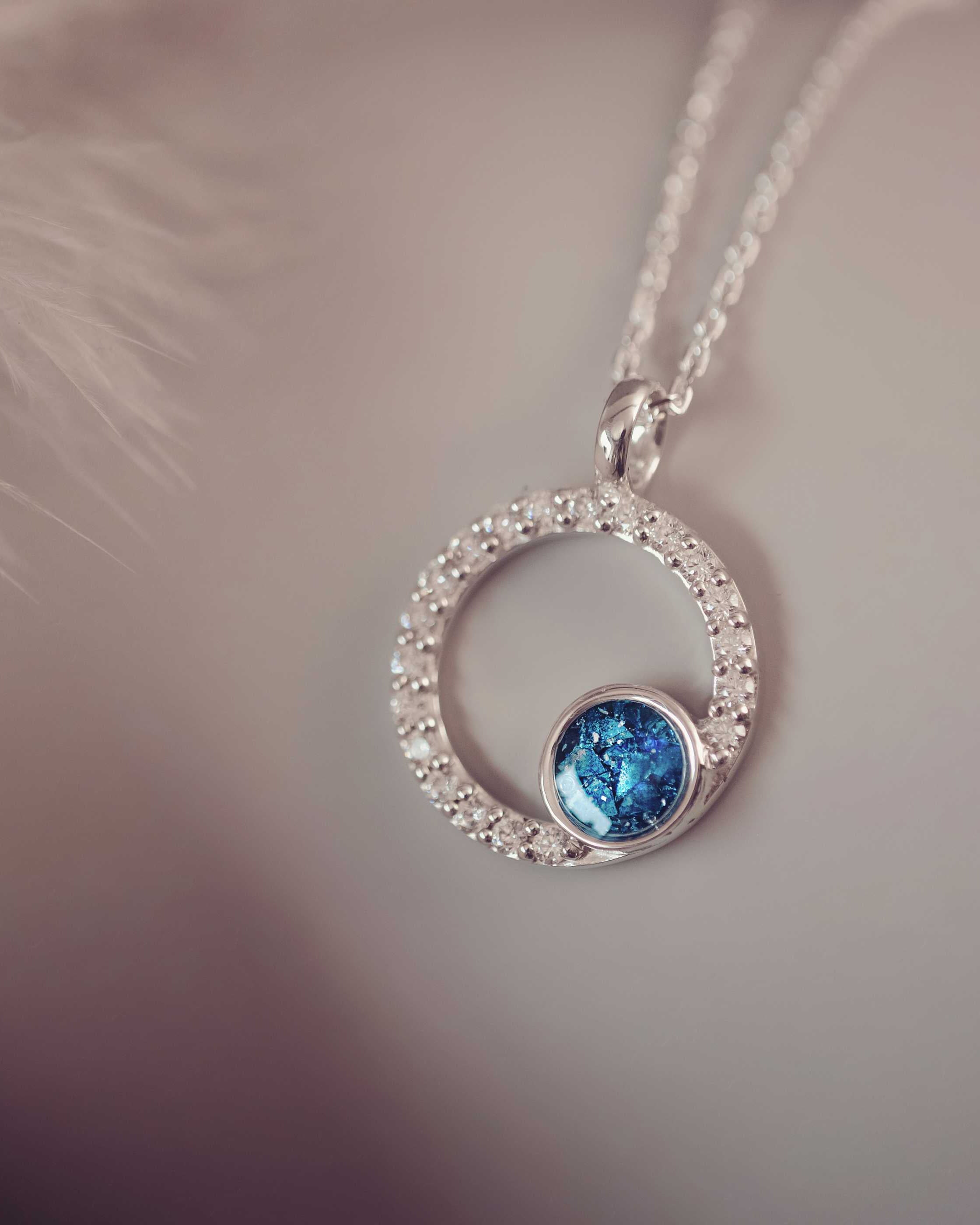 Silver necklace with a blue gemstone pendant on a blurred background