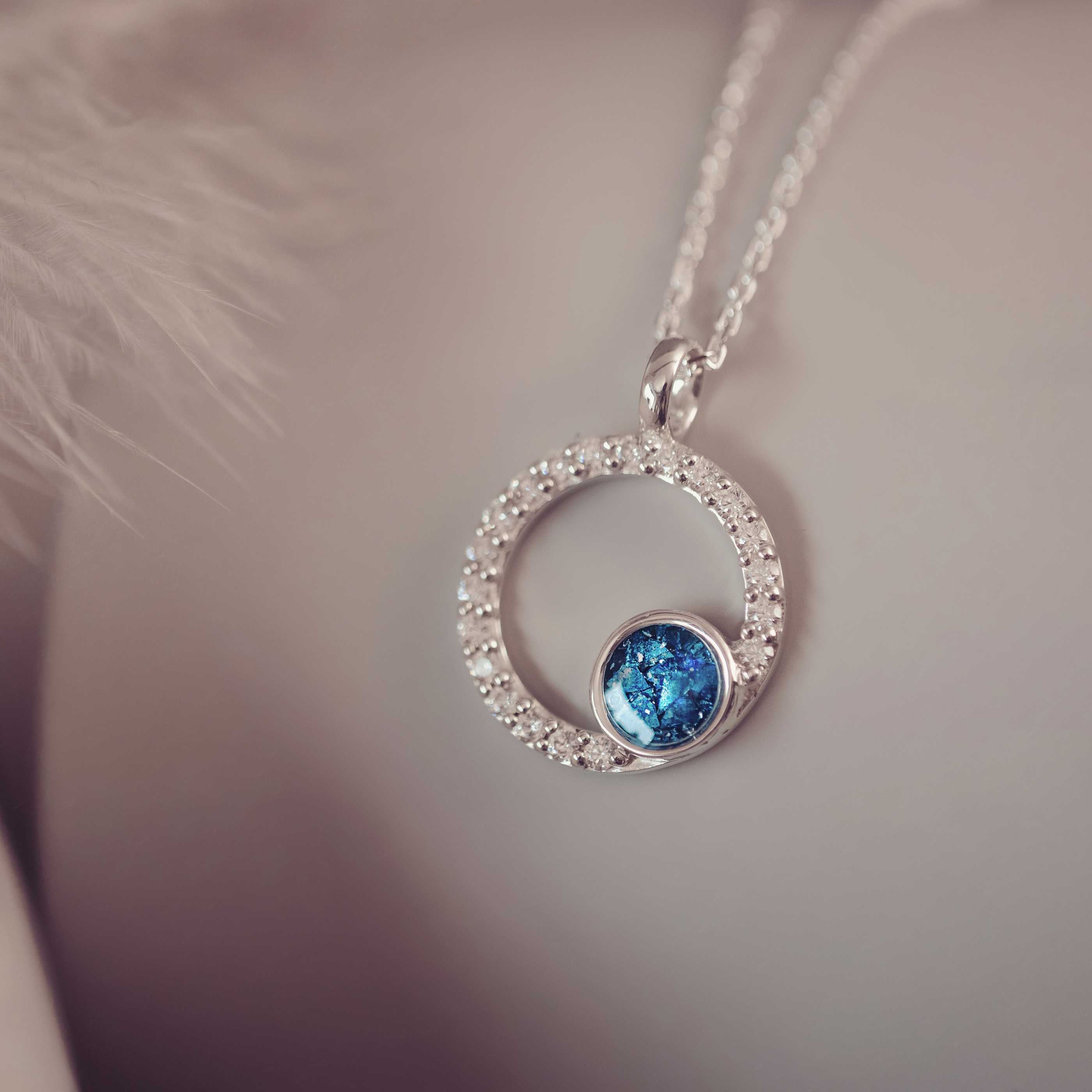 Silver necklace with a blue gemstone pendant on a blurred background