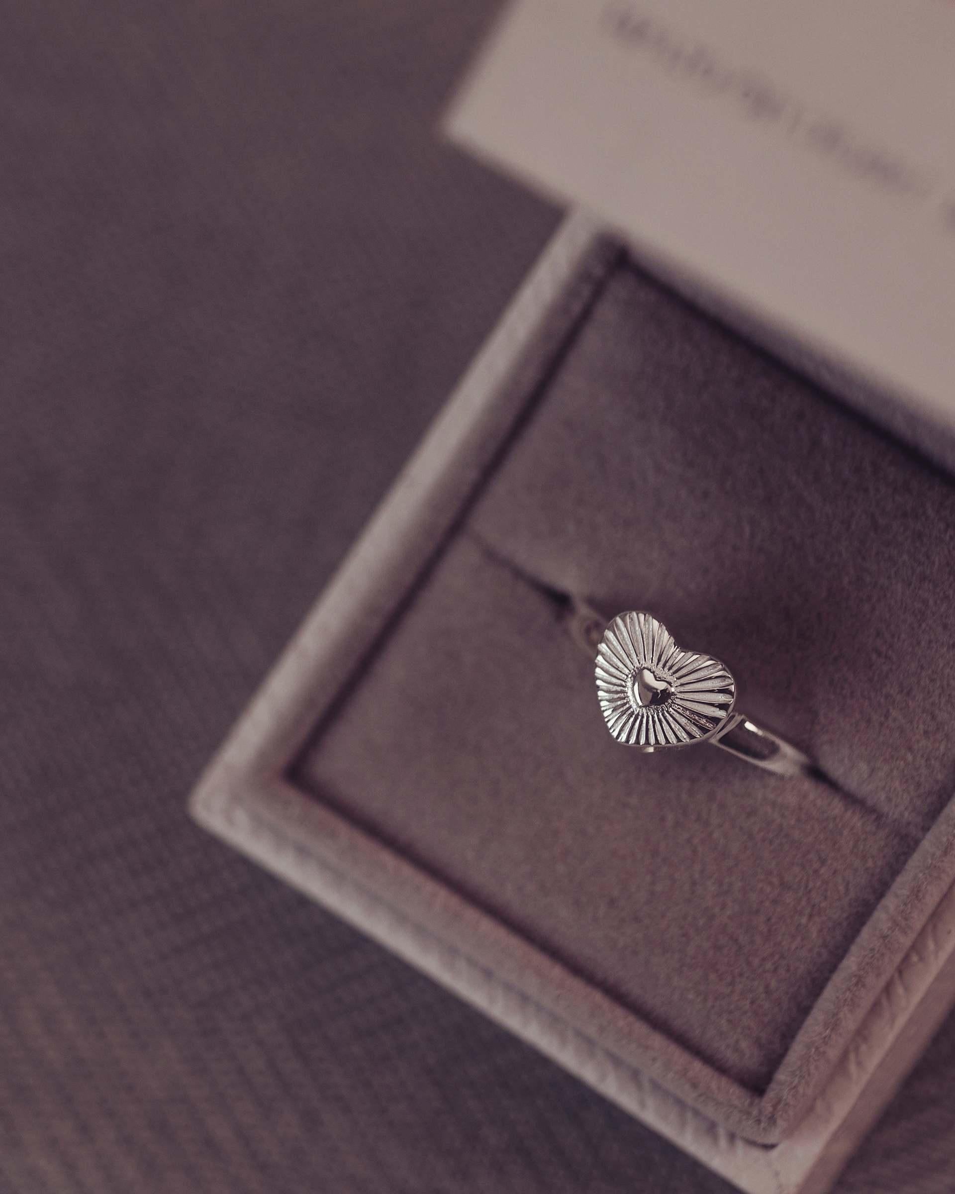 Silver ring in a jewelry box on a textured surface