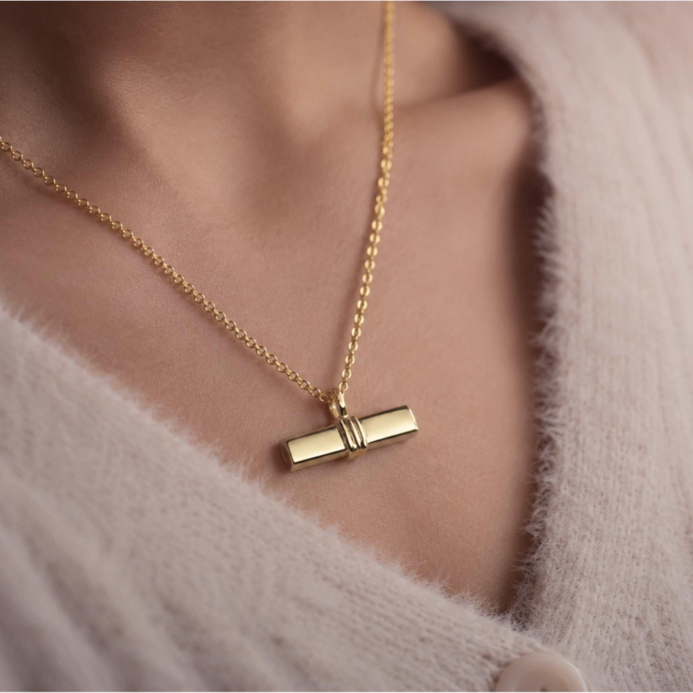 Gold T bar necklace sitting on a ladies neck