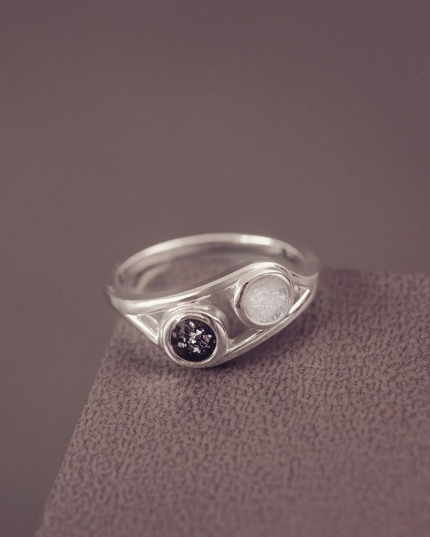 Silver ring with gemstones on a textured surface