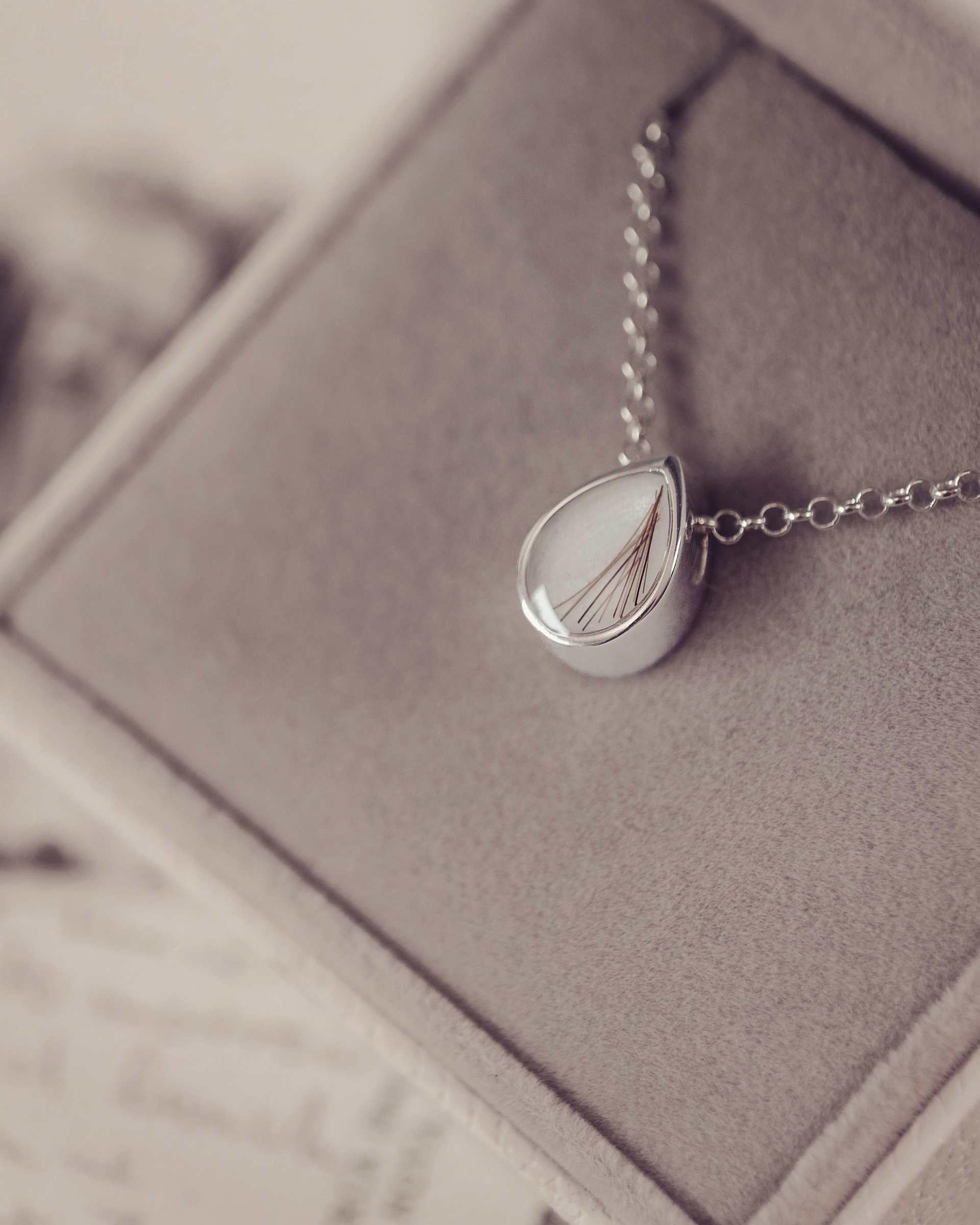 Silver necklace with a teardrop pendant in a jewellery box