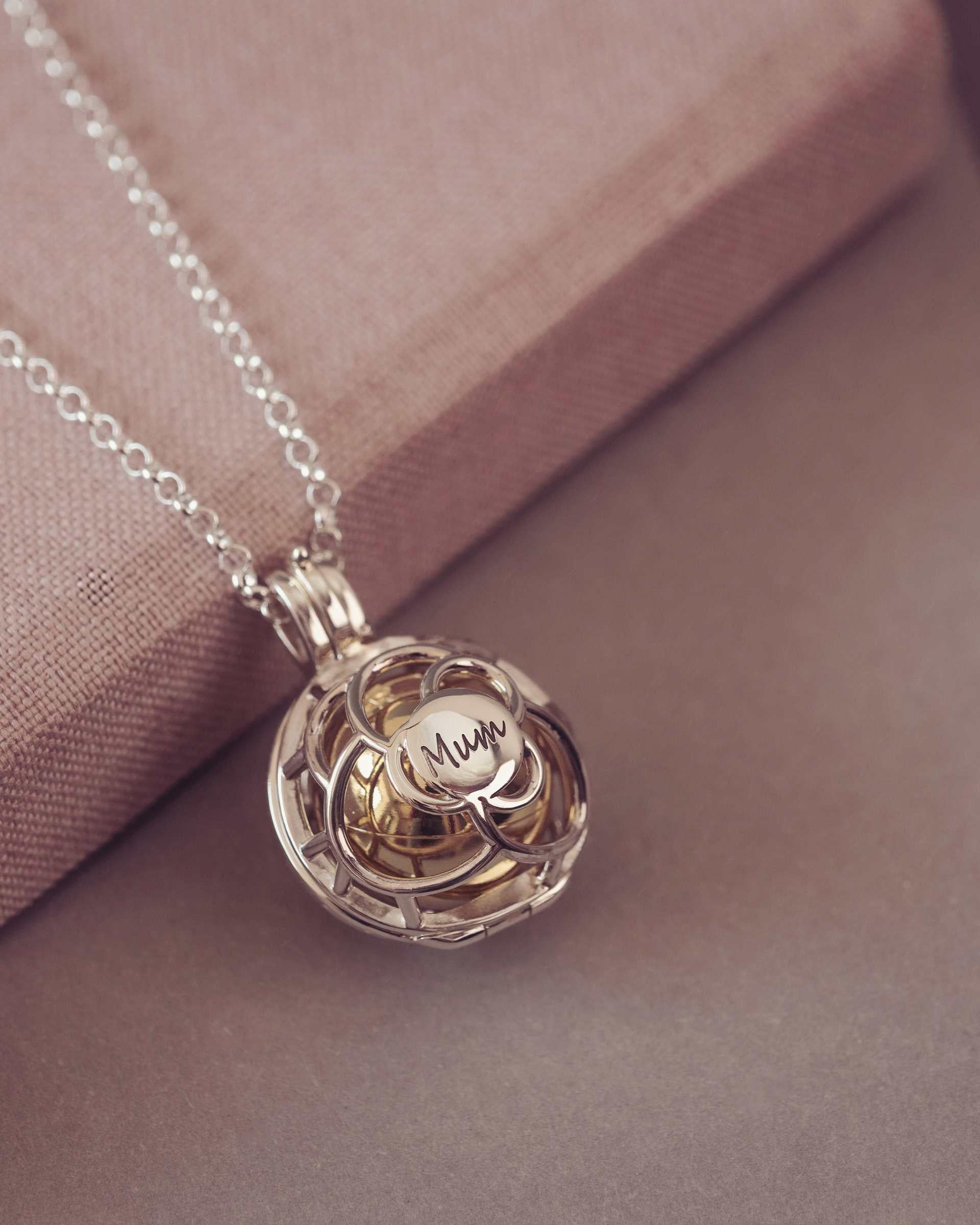 Silver and Gold pendant necklace with 'Mum' engraving on a soft pink background