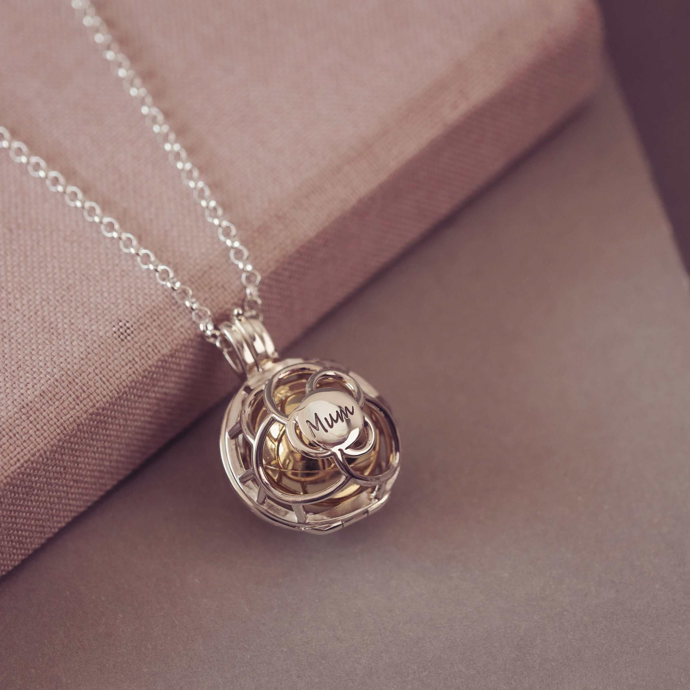 Silver and Gold pendant necklace with 'Mum' engraving on a soft pink background