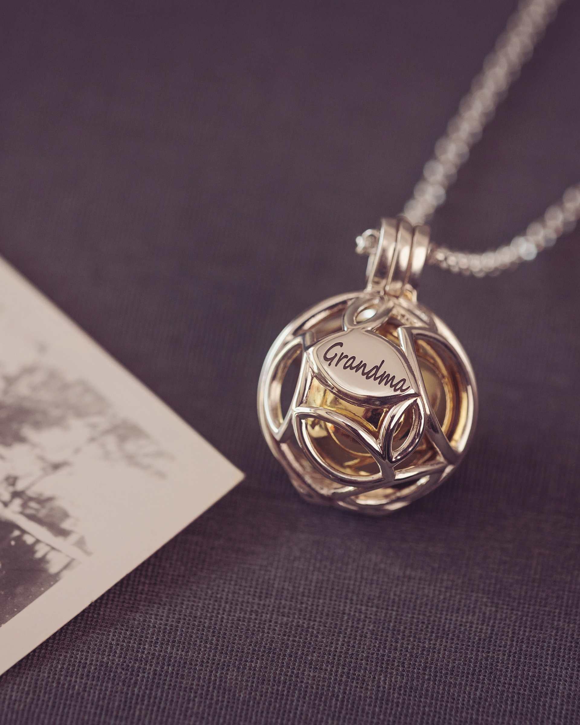 Silver necklace with a leaf pendant on a dark surface
