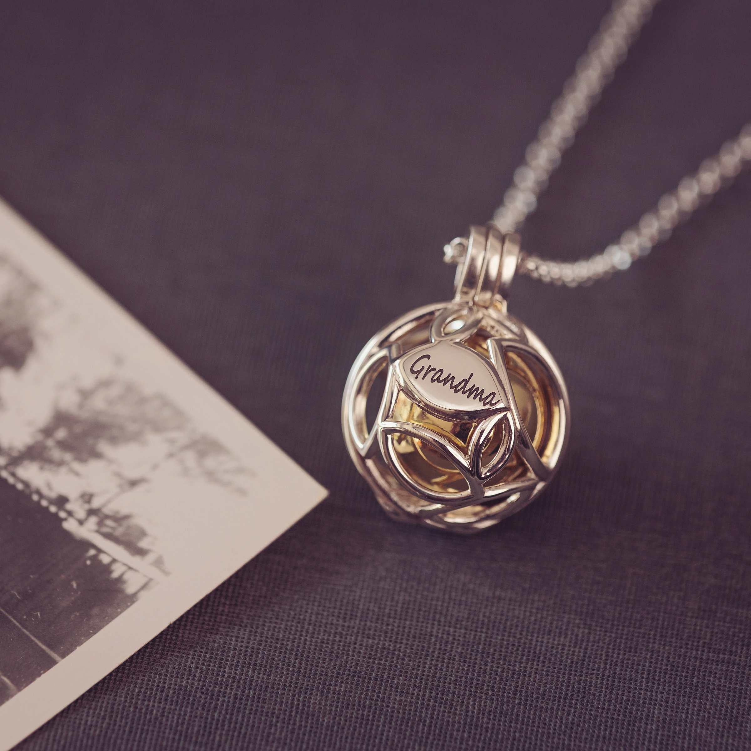 Silver necklace with a leaf pendant on a dark surface