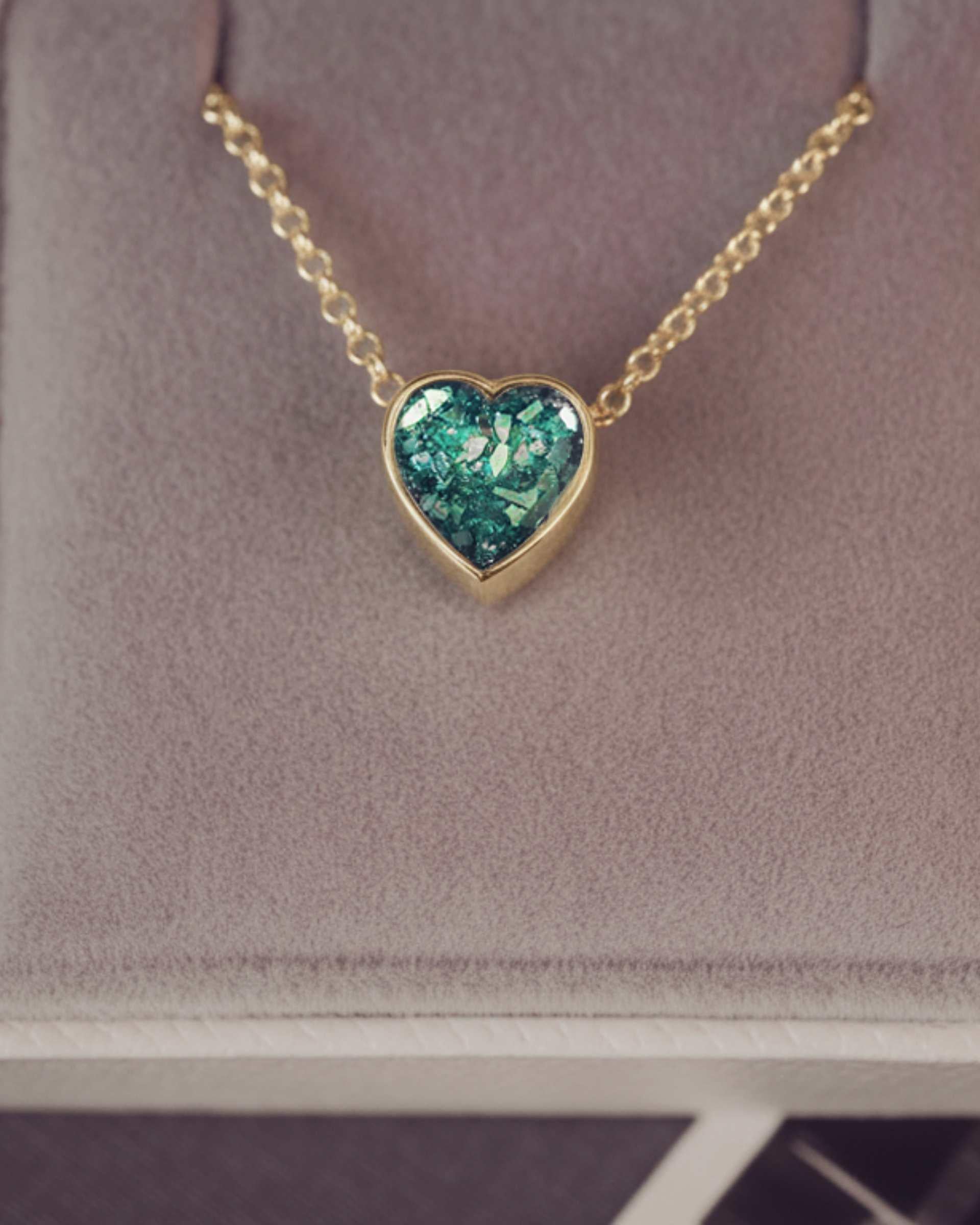 Heart-shaped green pendant necklace in a jewellery box