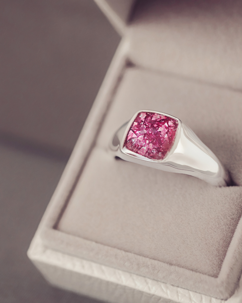 Silver ring with a pink gemstone in a jewelry box