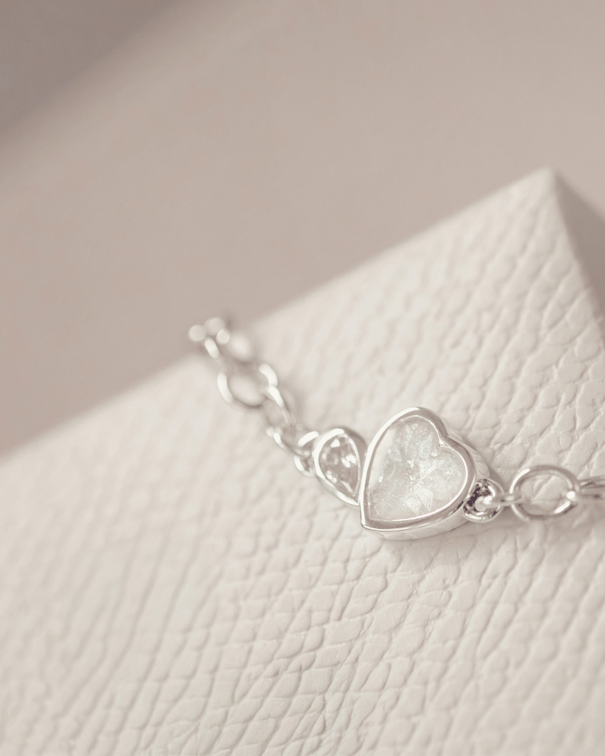 Silver bracelet with a heart-shaped setting on a textured surface