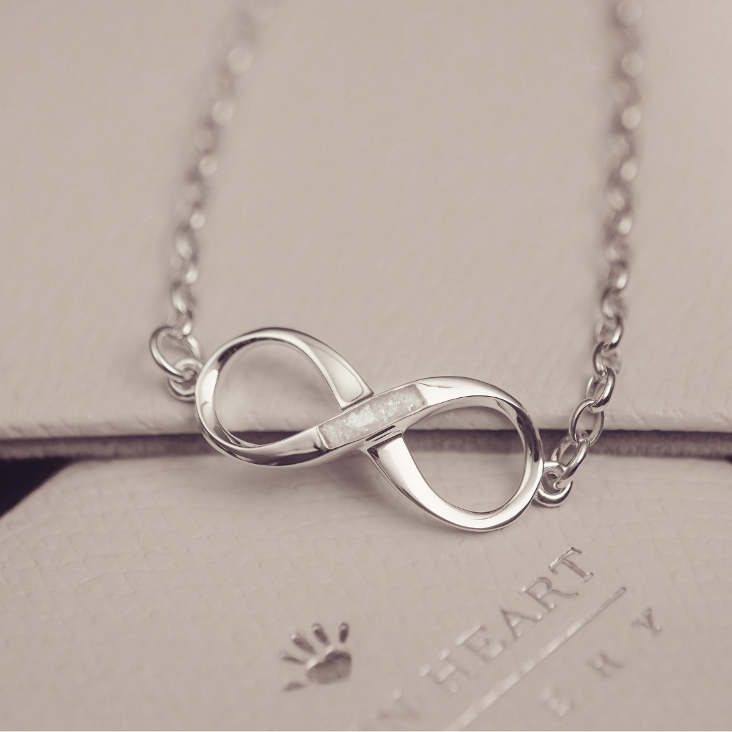 Silver infinity necklace on a light gray background