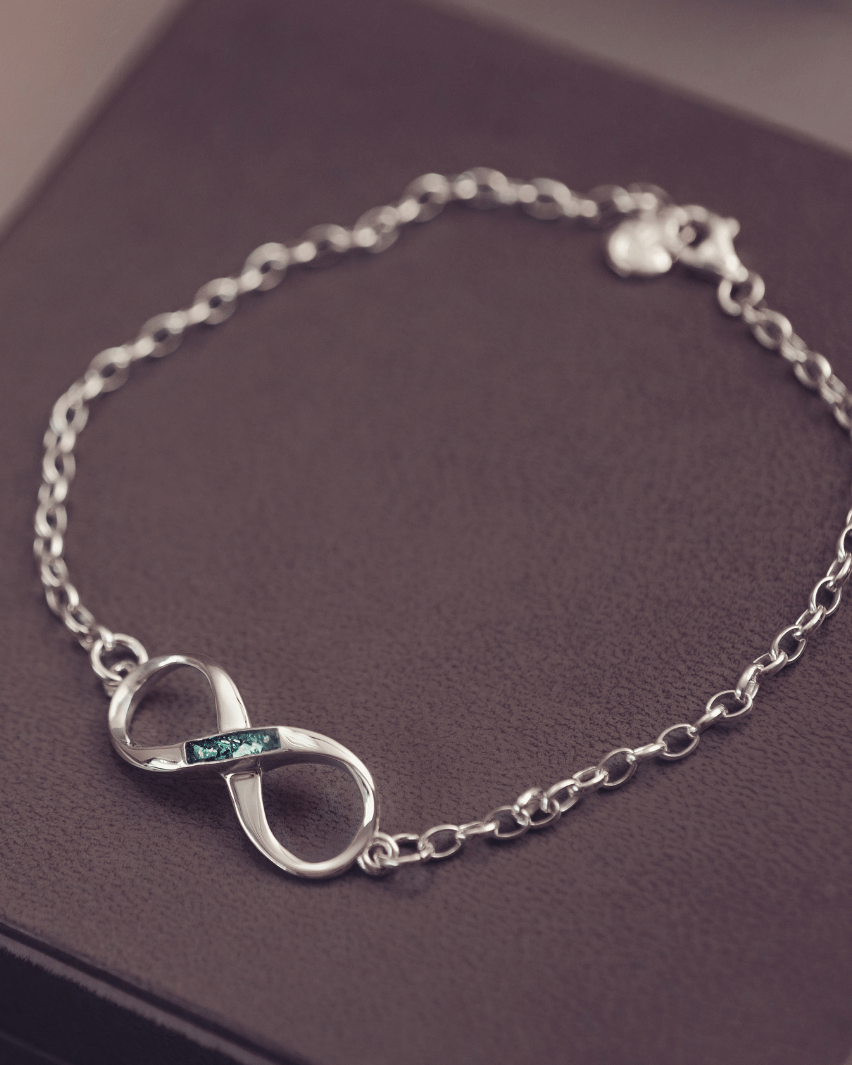 Silver bracelet with an infinity symbol on a purple surface