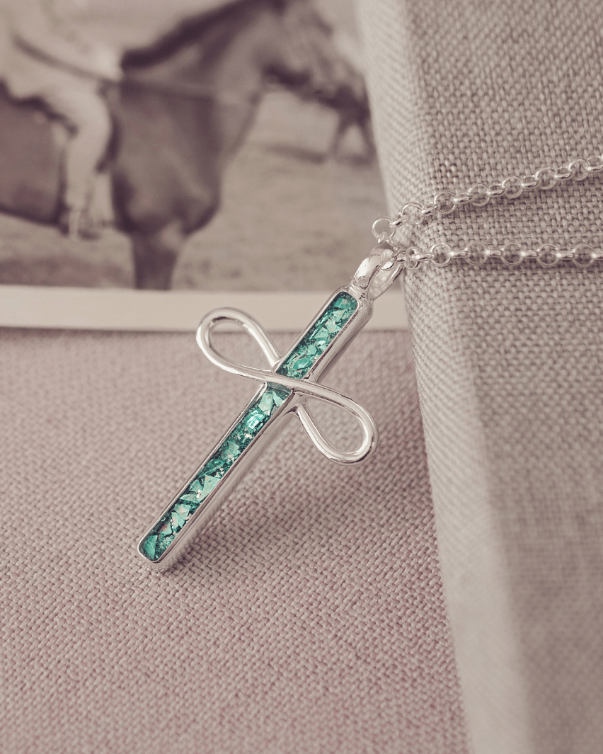 Necklace with a green and silver pendant on a textured surface