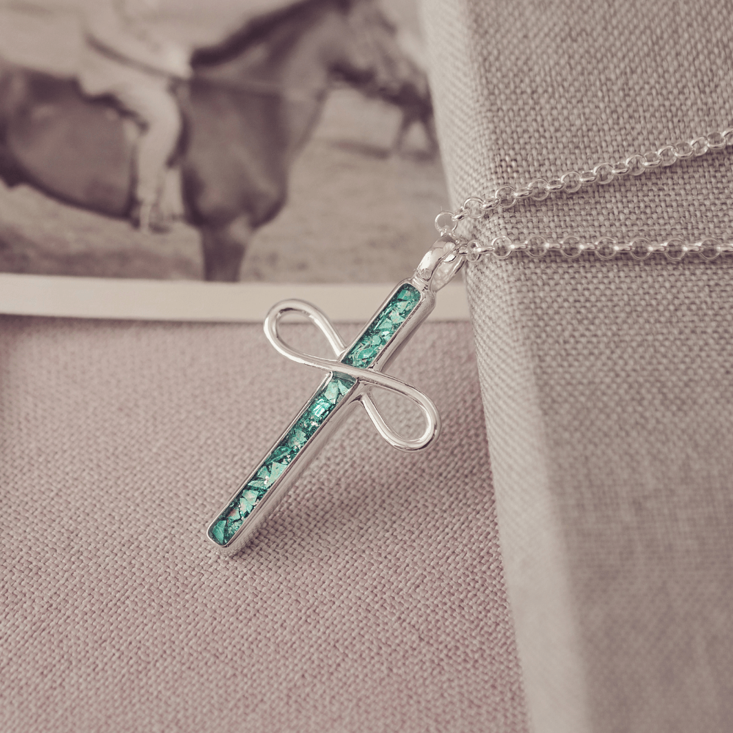 Necklace with a green and silver pendant on a textured surface