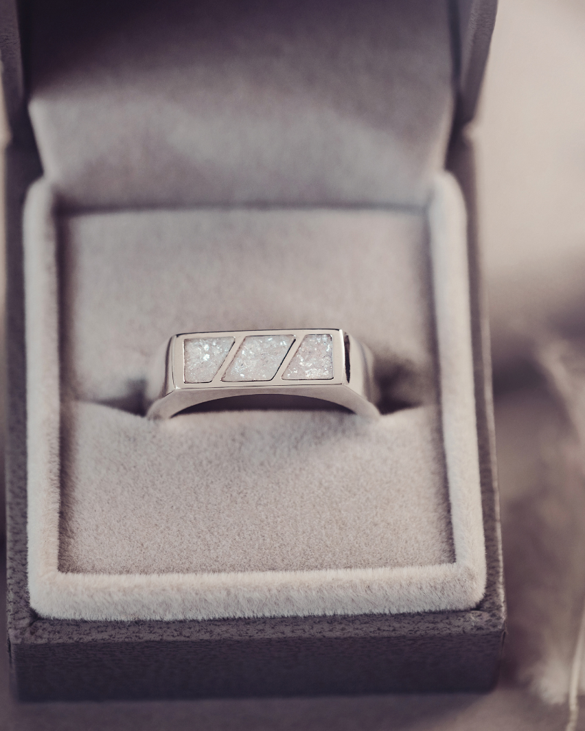 Silver ring with gemstones in a gray jewelry box