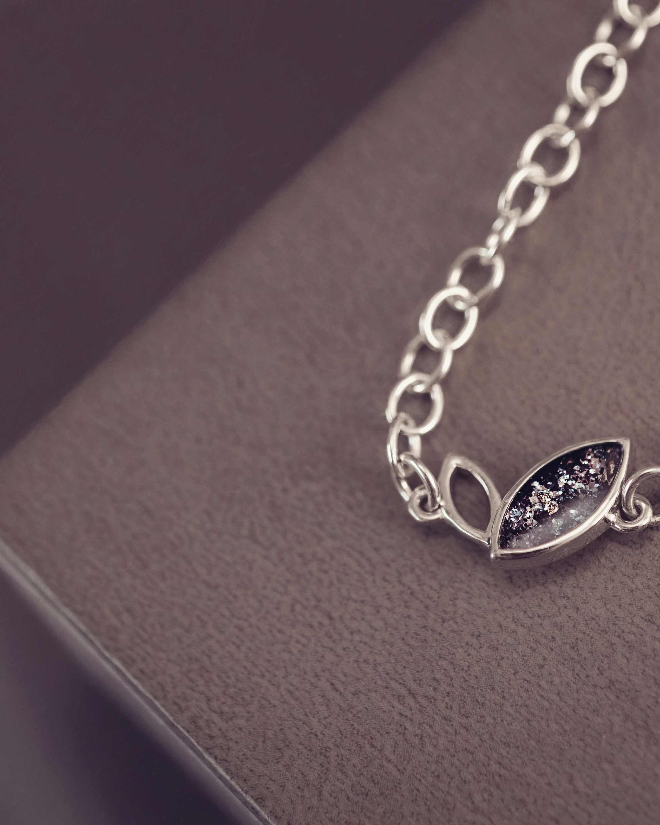 Silver bracelet with leaf design on a dark surface