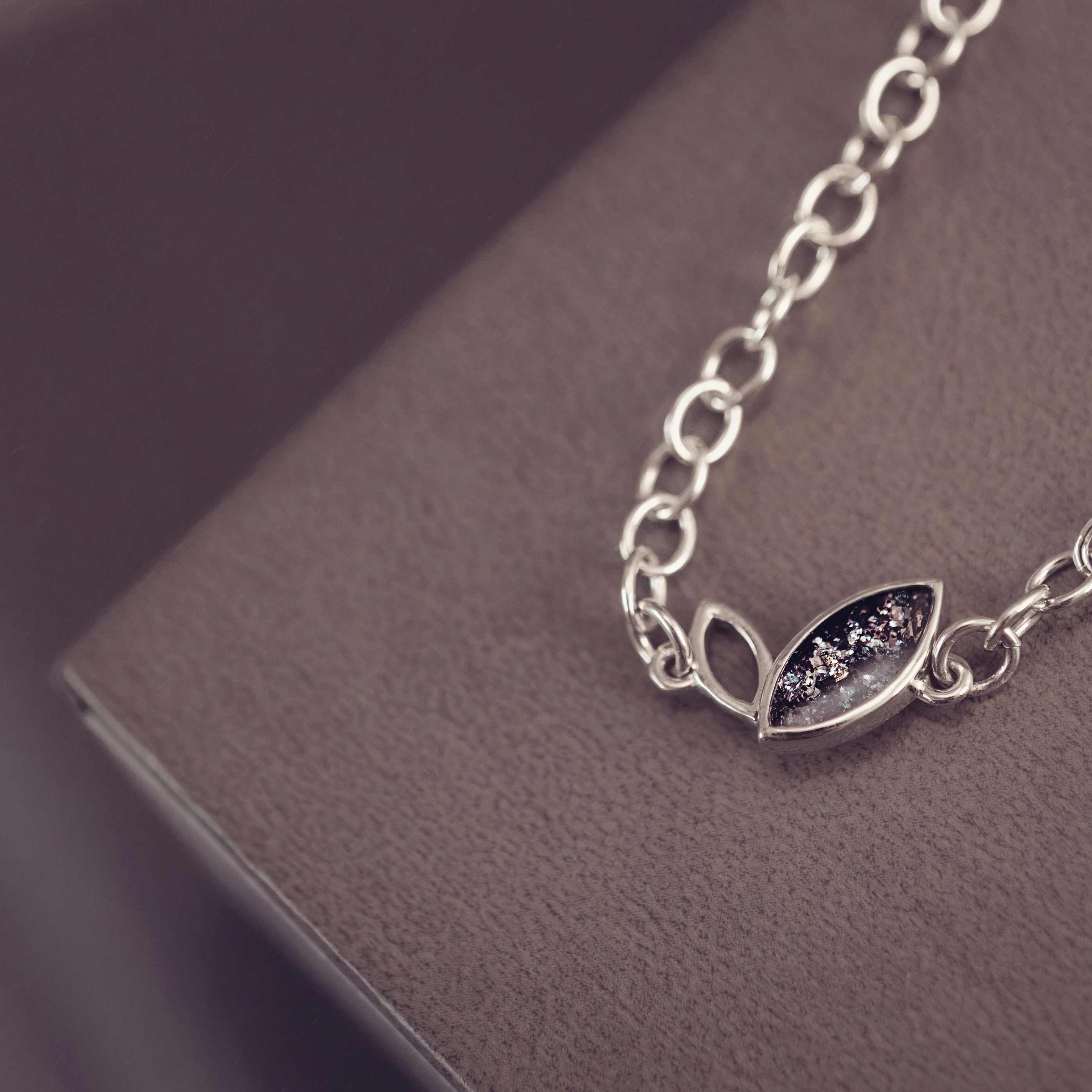 Silver bracelet with leaf design on a dark surface