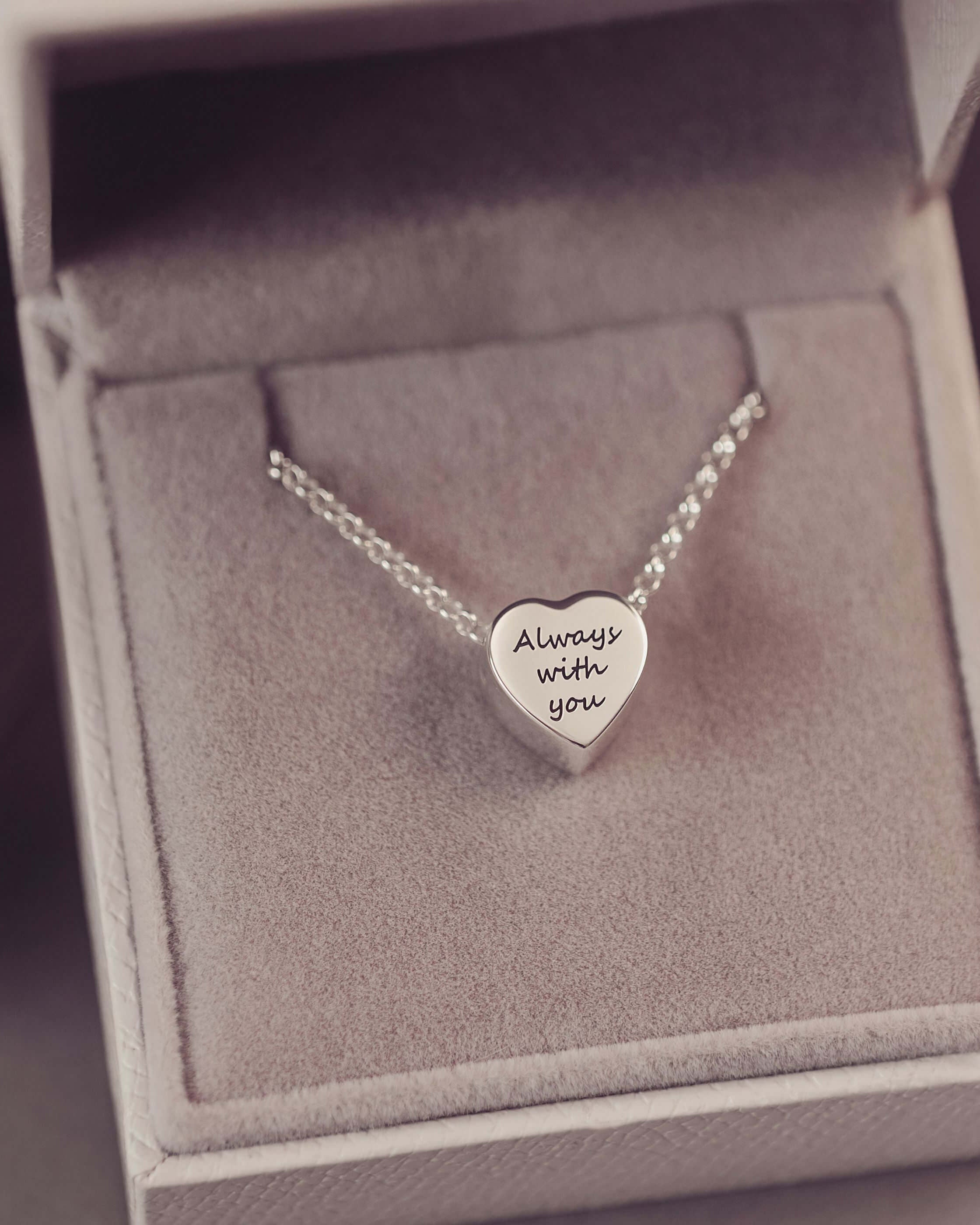 Silver heart-shaped necklace with 'Always with you' engraving in a box