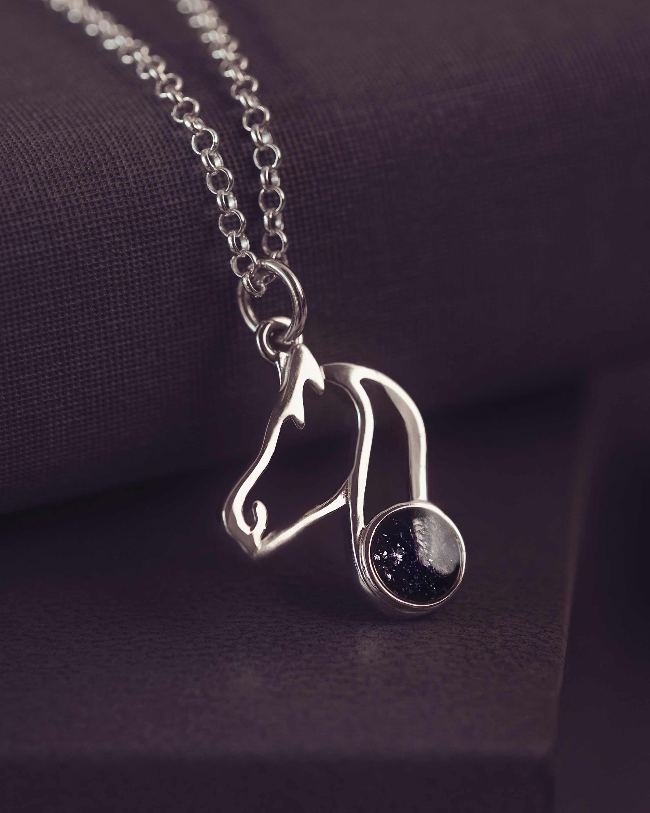 Silver Horse Shaped pendant on a silver chain with black gemstones