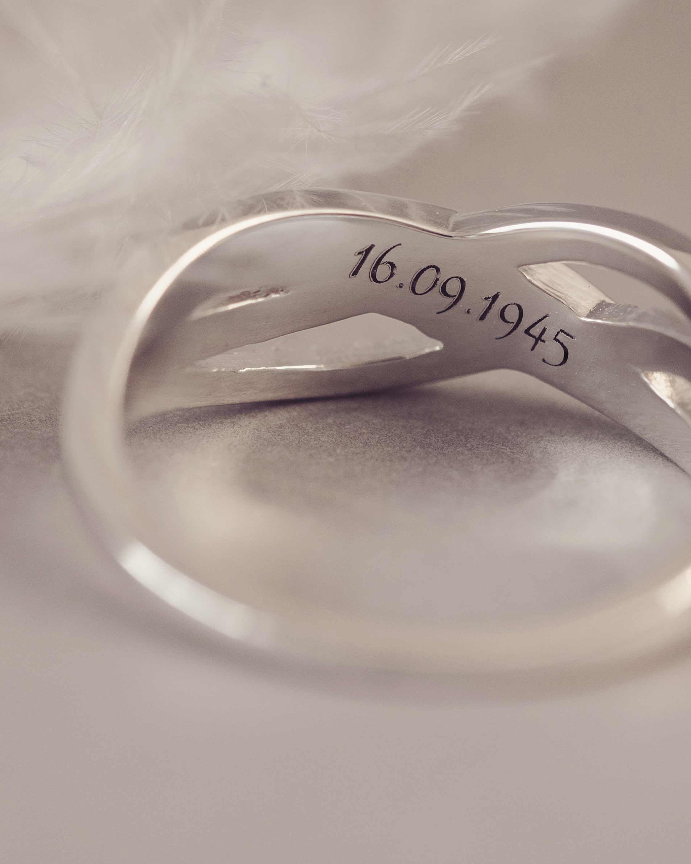 Silver ring with engraved date on a soft fabric background