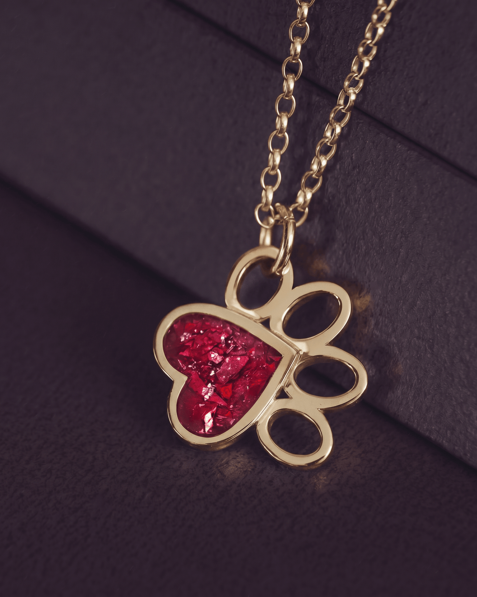 Gold pawprint shaped necklace with red gemstone setting