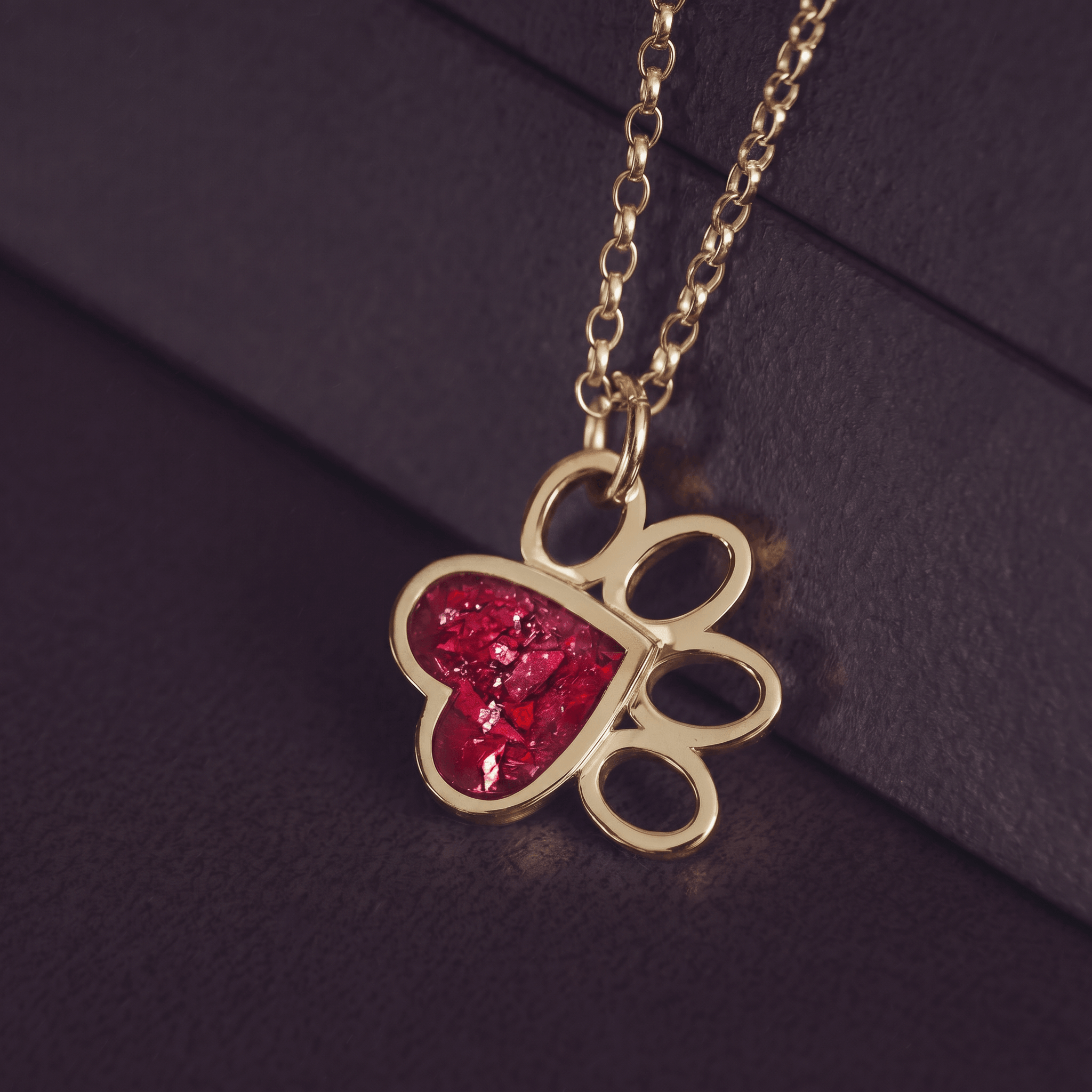 Gold pawprint shaped necklace with red gemstone setting