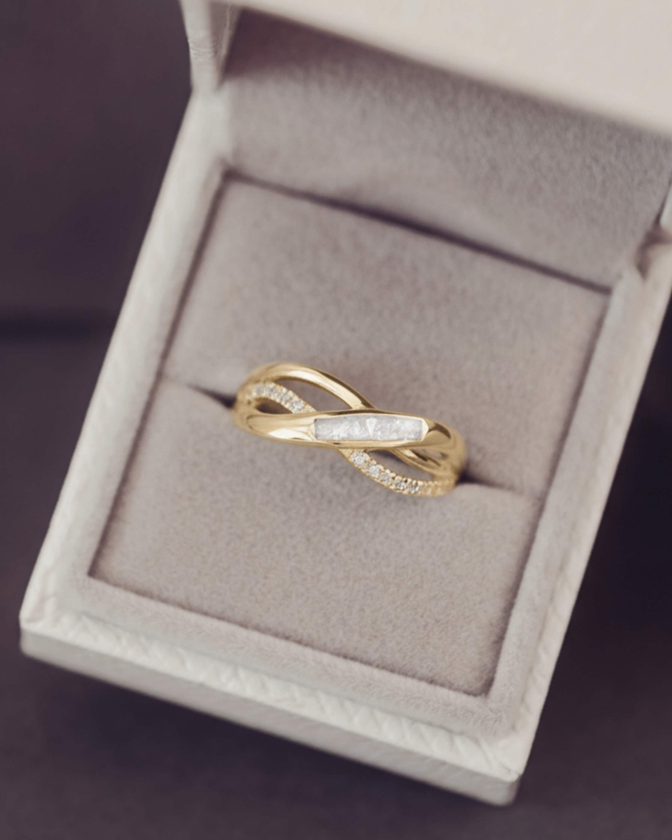 Gold ring with diamonds in a jewelry box on a dark background