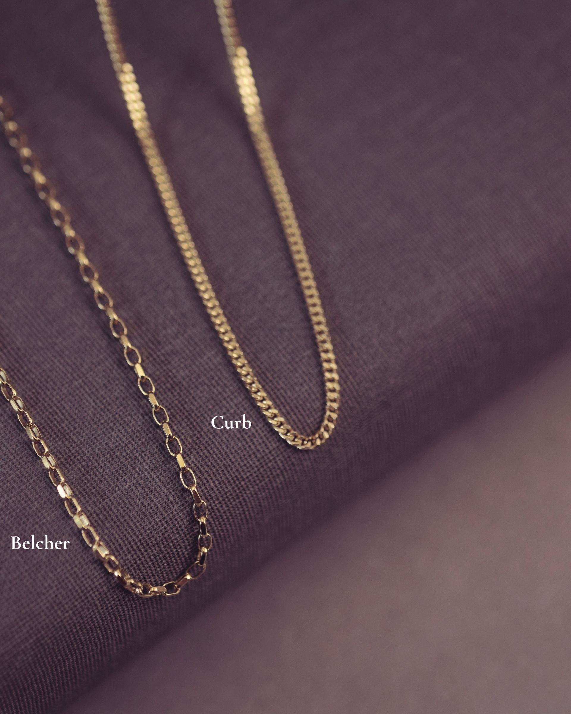 Gold chain necklace on a purple fabric background with 'Curb' and 'Belcher' labels.