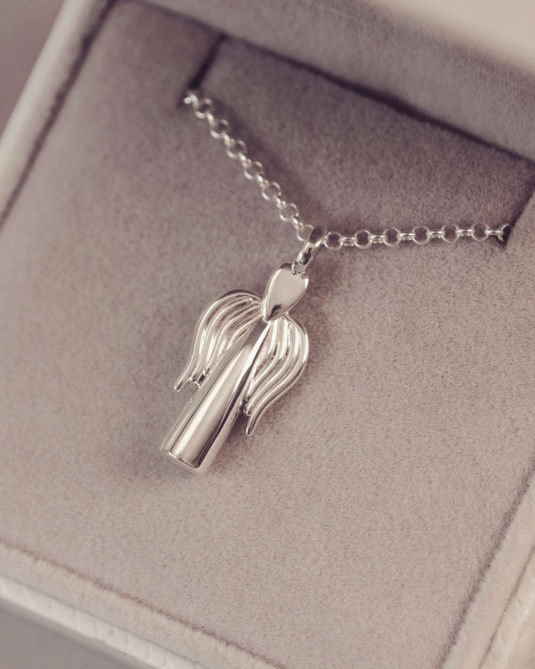 Silver necklace with a unique pendant on a soft gray background