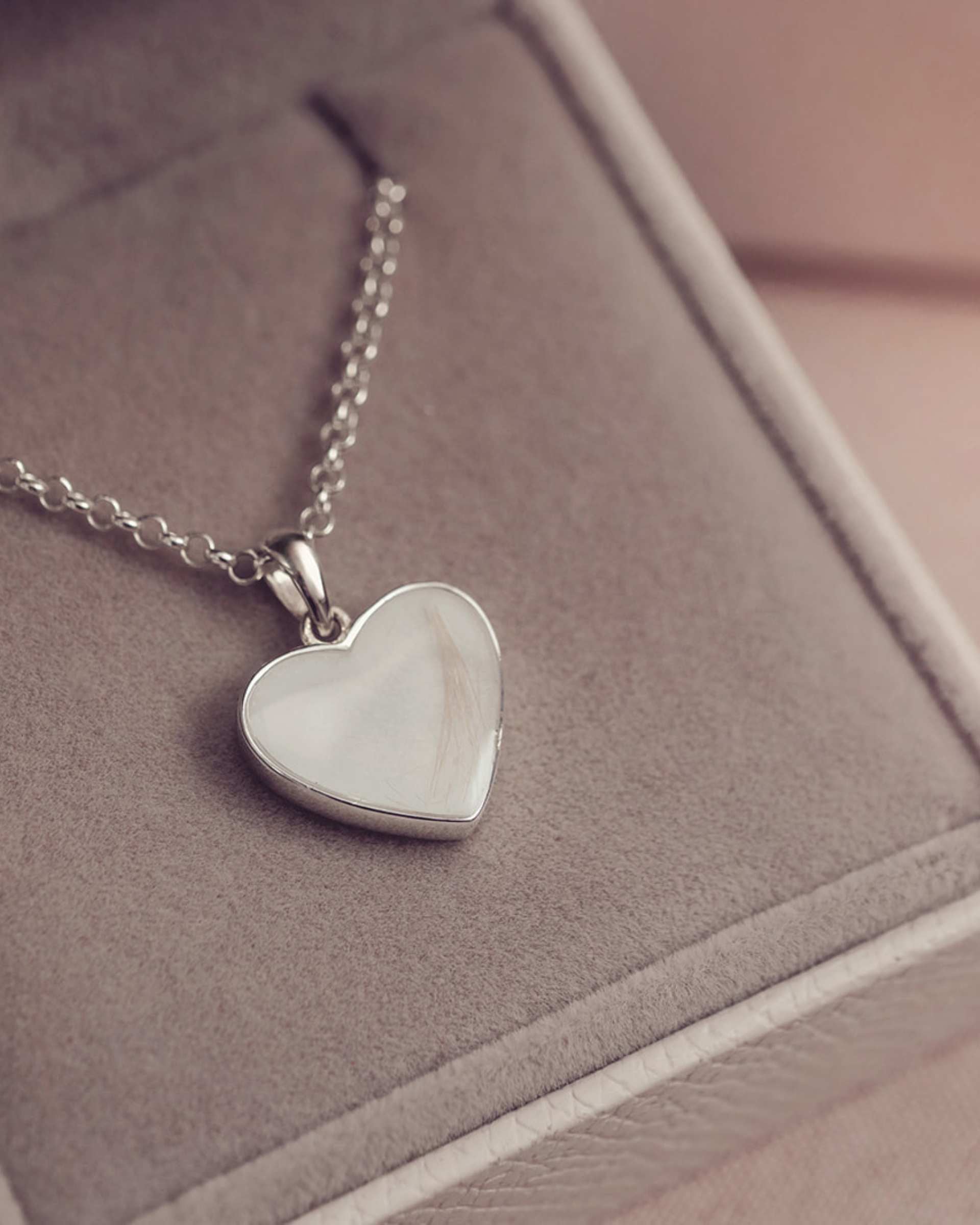 Silver heart-shaped pendant necklace on a soft surface