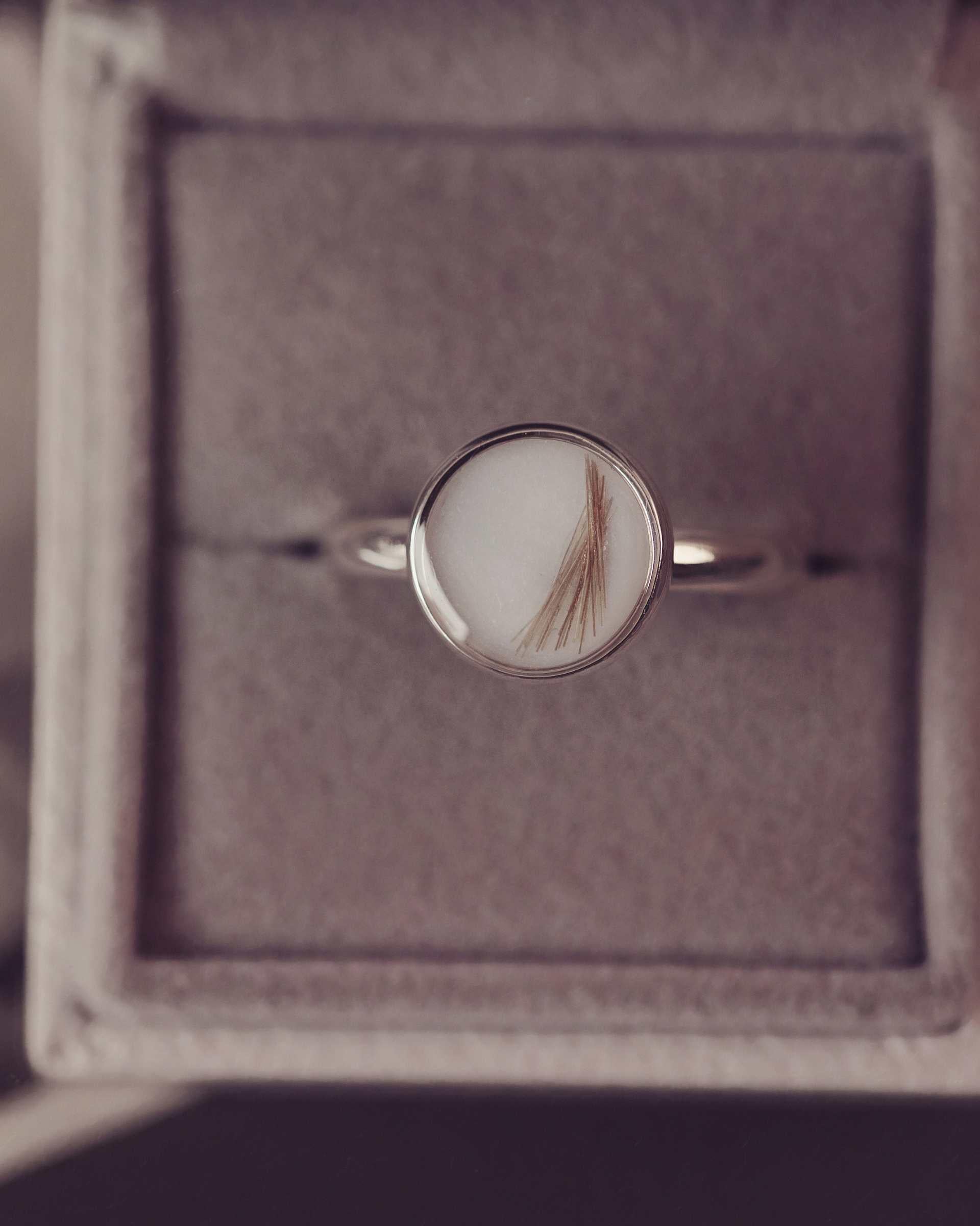 Silver ring with a circular stone in a jewellery box