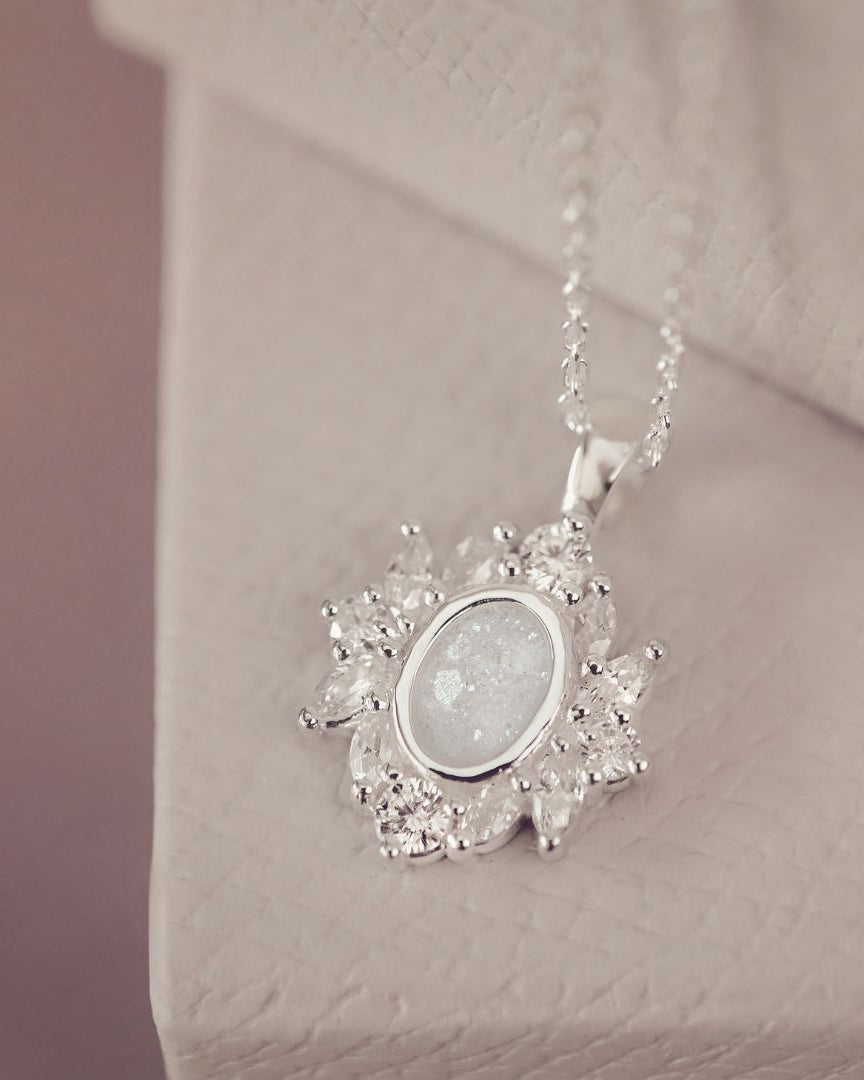 Silver necklace with a pendant on a soft pink background