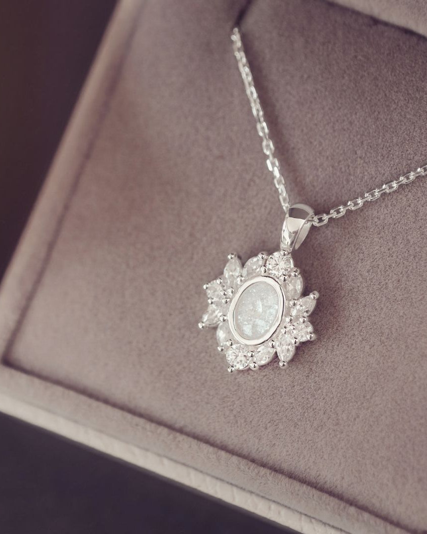A silver necklace with silver gem stones on a purple background