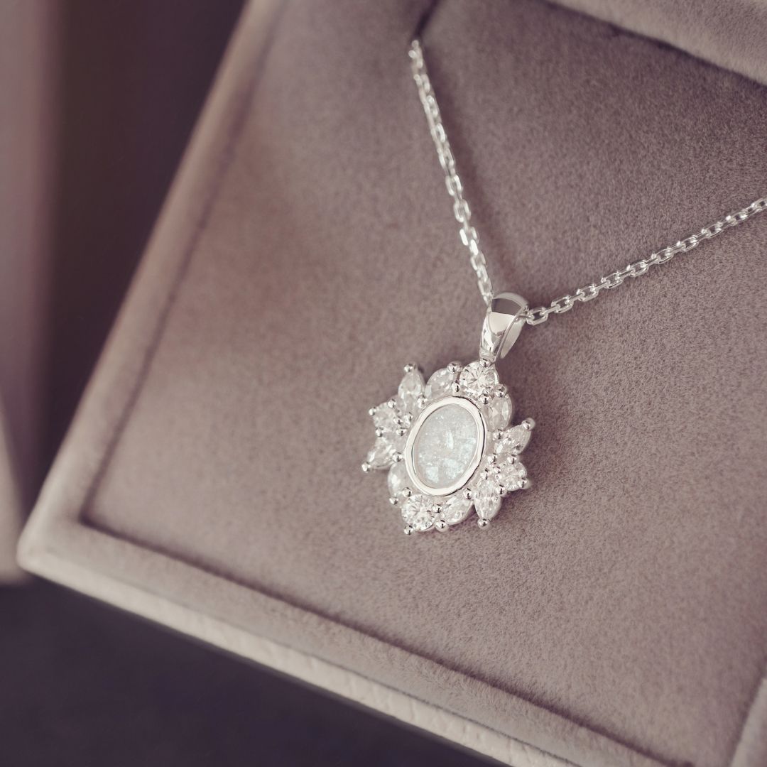 A silver necklace with silver gem stones on a purple background