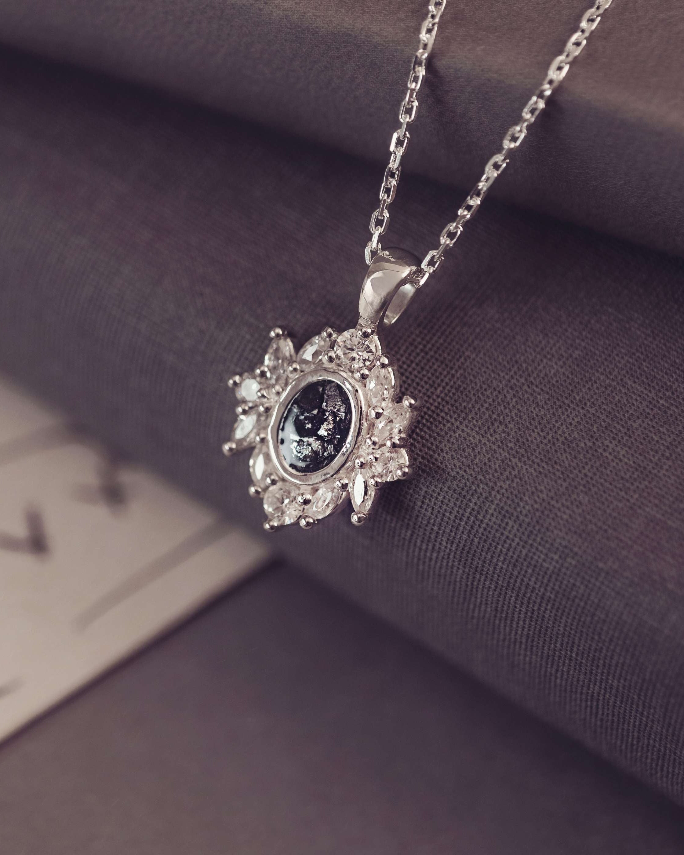 Silver necklace with a decorative pendant on a textured surface