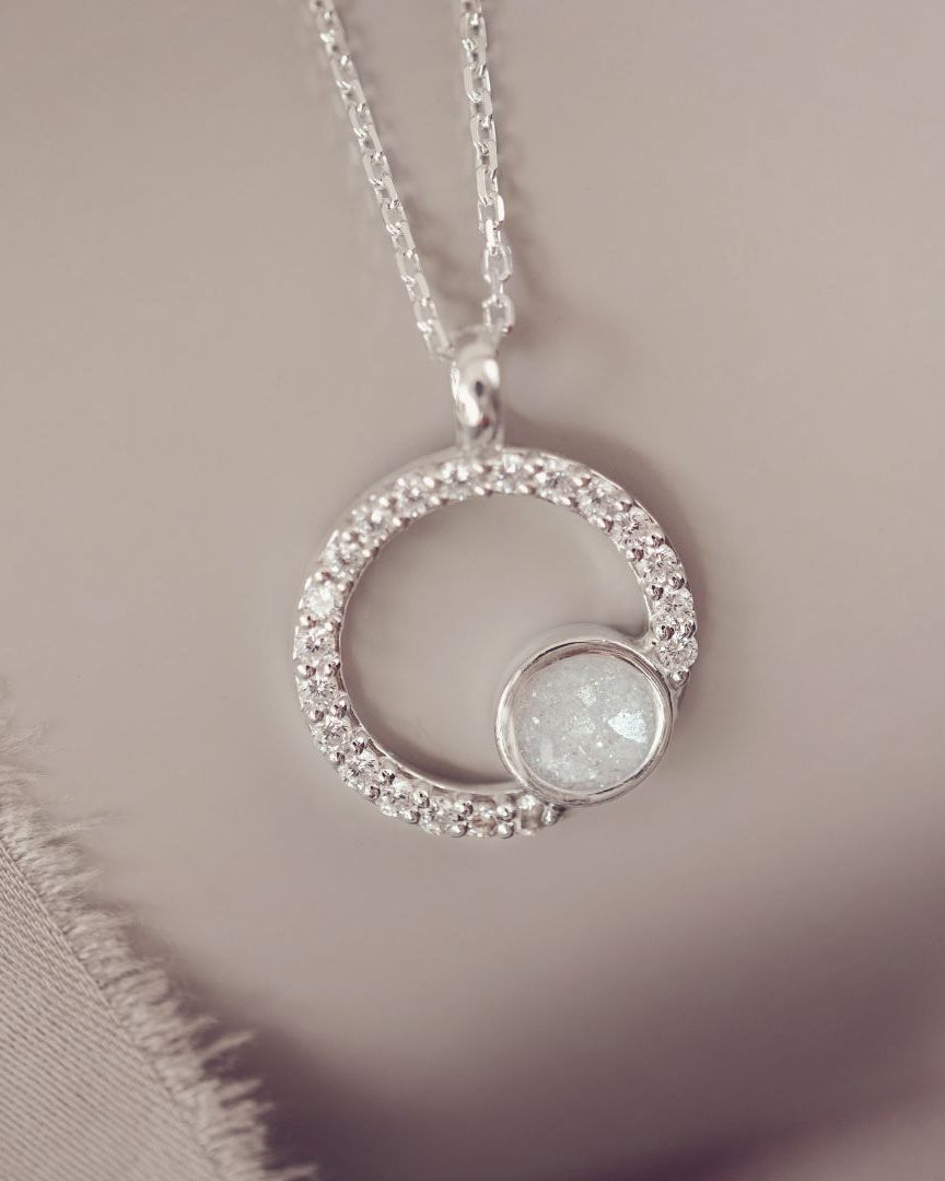 Silver necklace with a circular pendant on a soft background