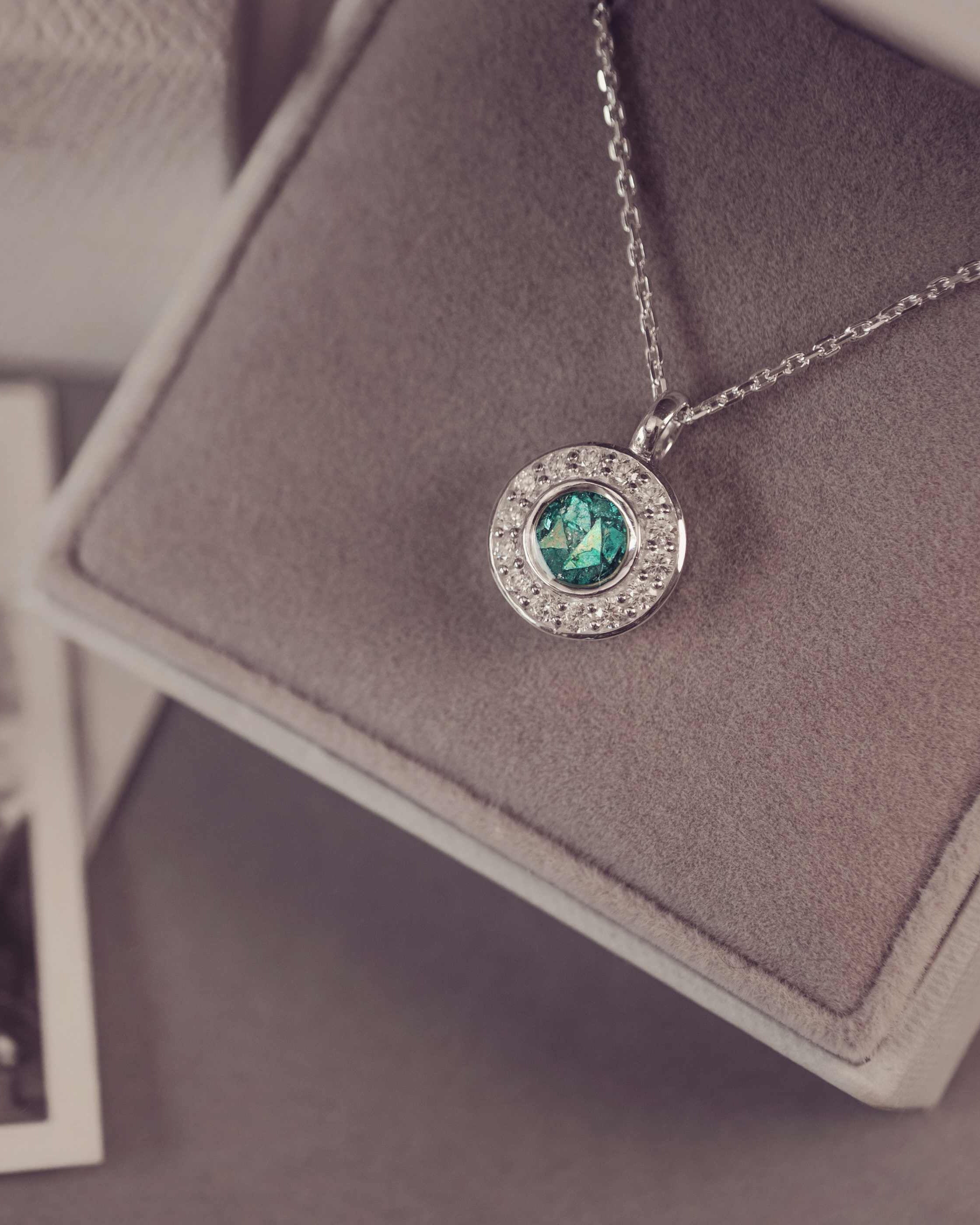 Necklace with a green gemstone pendant on a gray surface