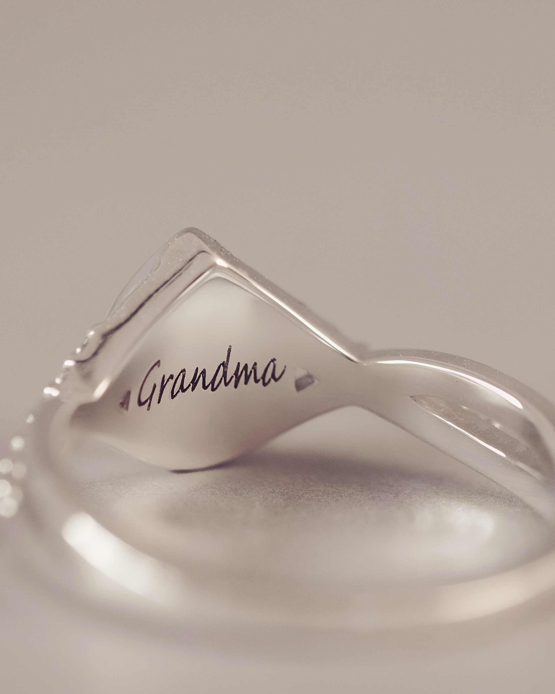 Silver ring with 'Grandma' engraved on a light background