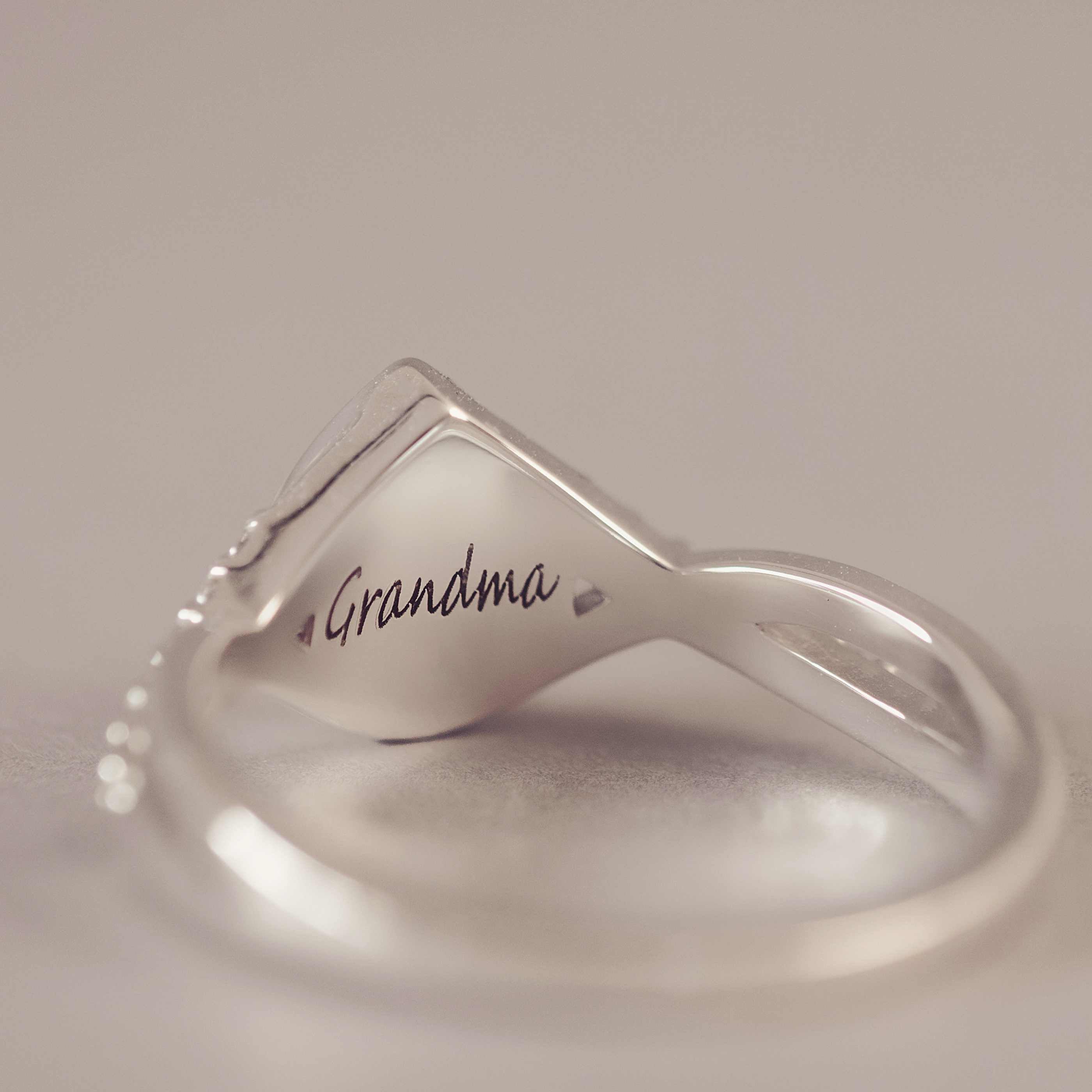 Silver ring with 'Grandma' engraved on a light background