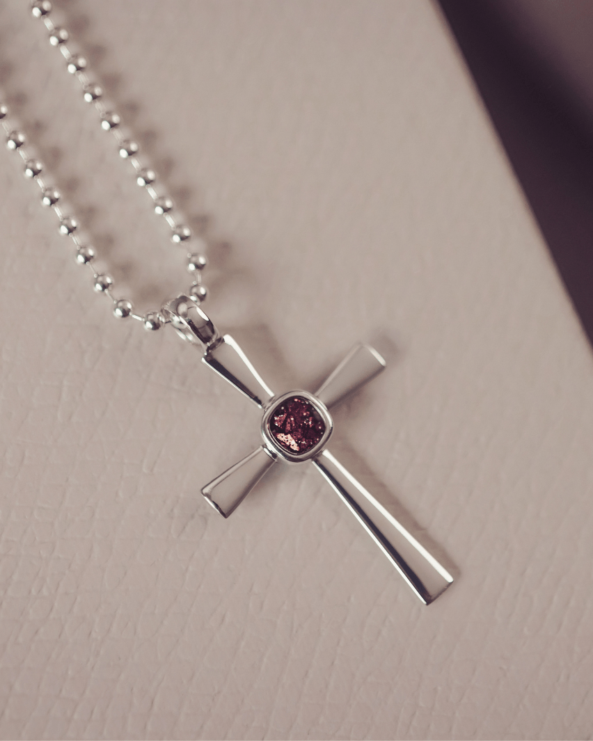 silver cross necklace holding cremation ashes, resin and brown crystal