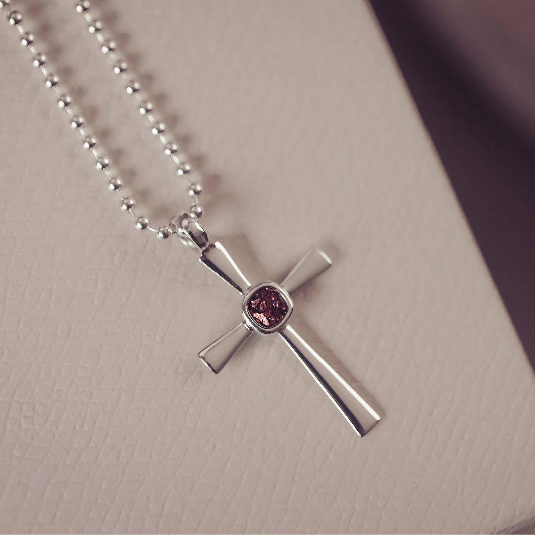 silver cross necklace holding cremation ashes, resin and brown crystal
