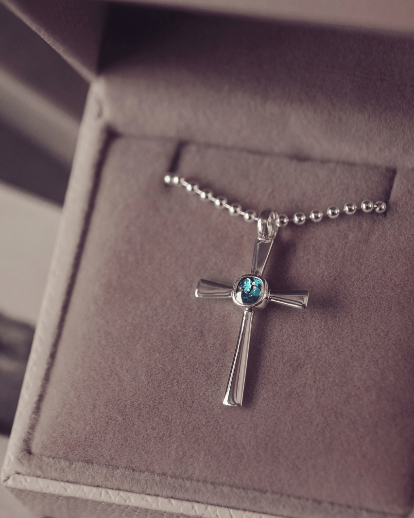silver cross necklace holding cremation ashes, resin and turquoise crystal