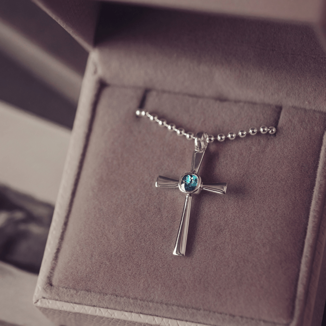 silver cross necklace holding cremation ashes, resin and turquoise crystal