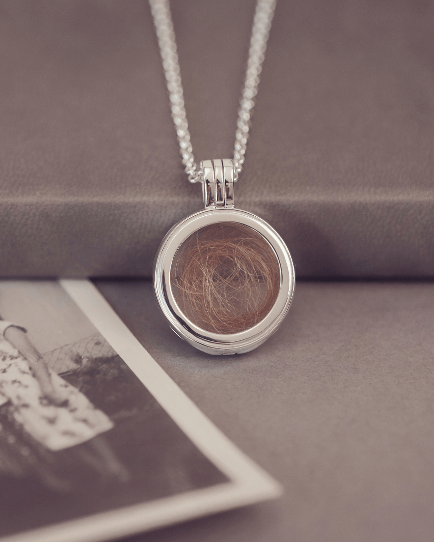 Round silver locket necklace with acrylic showing a locket of hair inside