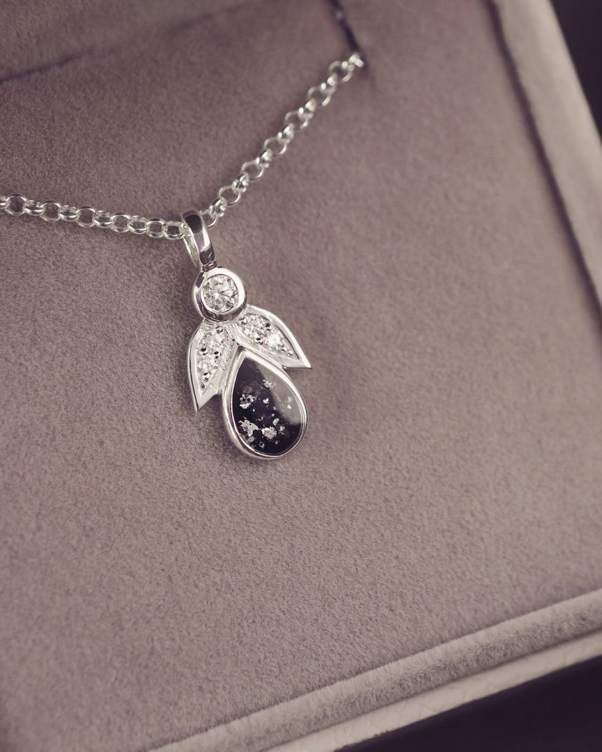 Silver pendant necklace on a gray cushioned jewelry box