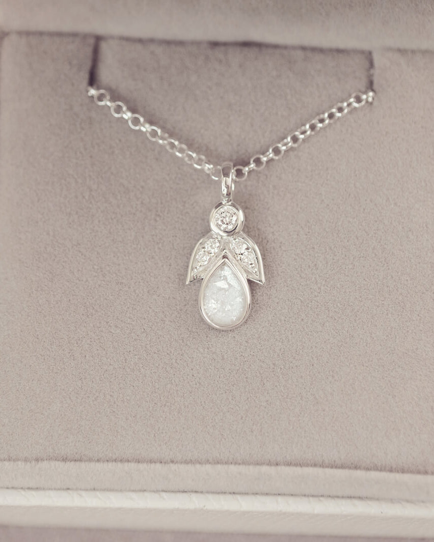 sterling silver angel pendant with clear floating crystals sat in a grey jewellery box