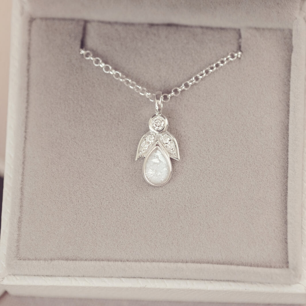sterling silver angel pendant with clear floating crystals sat in a grey jewellery box